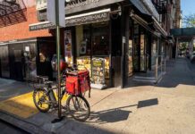 Delivery bicycle parked outside a corner deli