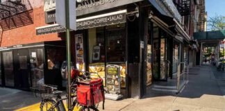 Delivery bicycle parked outside a corner deli