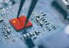 Microchip with China flag held by tweezers on circuit board