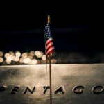 China’s Sub Surge Stuns Pentagon A small American flag positioned in front of the word 'PENTAGON' on a reflective surface