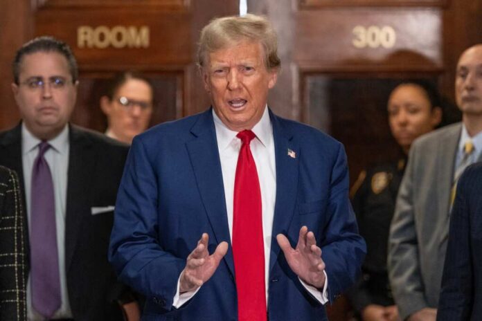 A public figure speaking at a press conference in a courtroom