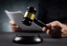 Lenient Sentence Ignites Immigration Firestorm A gavel held above a sounding block with a person reading documents in the background