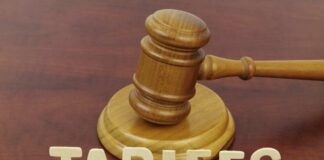 A wooden gavel next to the word 'TARIFFS' spelled out in wooden letters