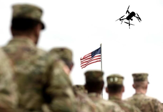 shutterstock_2690863839 Military personnel standing in formation with a drone flying overhead and an American flag in the background