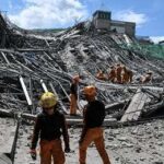 Rescue workers search a collapsed building site