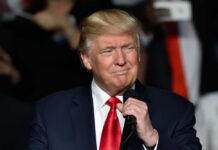 Elite Takeover at War College Donald Trump speaking at a rally with a microphone