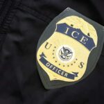 Supremacy Bombshell Freezes NY Crackdown ICE officer badge on a dark uniform