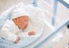 Newborn baby sleeping in hospital bassinet