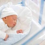 Newborn baby sleeping in hospital bassinet