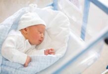 Newborn baby sleeping in hospital bassinet