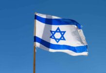 Israeli flag waving against a clear blue sky
