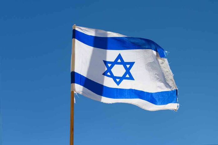 Israeli flag waving against a clear blue sky