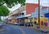 Main street with colorful storefronts and pedestrians at dusk