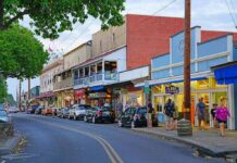 Main street with colorful storefronts and pedestrians at dusk