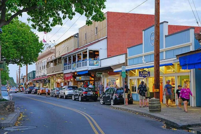 shutterstock_1272213661 Main street with colorful storefronts and pedestrians at dusk