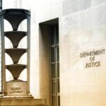 Department of Justice building exterior with sign and metal sculpture