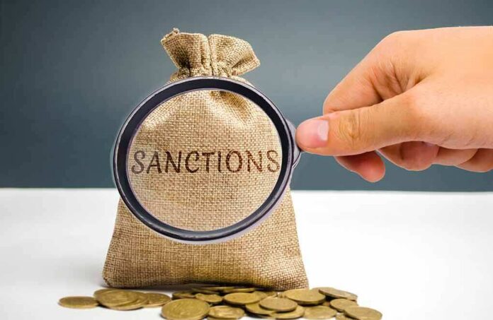 hand holding magnifying glass over burlap money bag with coins