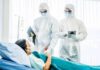 Healthcare workers in full PPE attending to a hospital patient