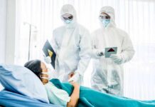 Healthcare workers in full PPE attending to a hospital patient