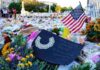 Memorial site with flowers and a U.S. flag