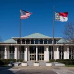 government building with US and state flags at the entrance