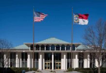 government building with US and state flags at the entrance