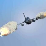 fighter jet firing two missiles in flight