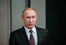 man in suit speaking at a podium