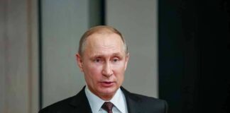 man in suit speaking at a podium