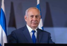 Iran Bombshell: Did Netanyahu Dupe America? man in suit at podium with flags in background