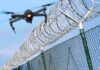 Drone flying near barbed wire security fence