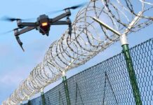 Drone flying near barbed wire security fence