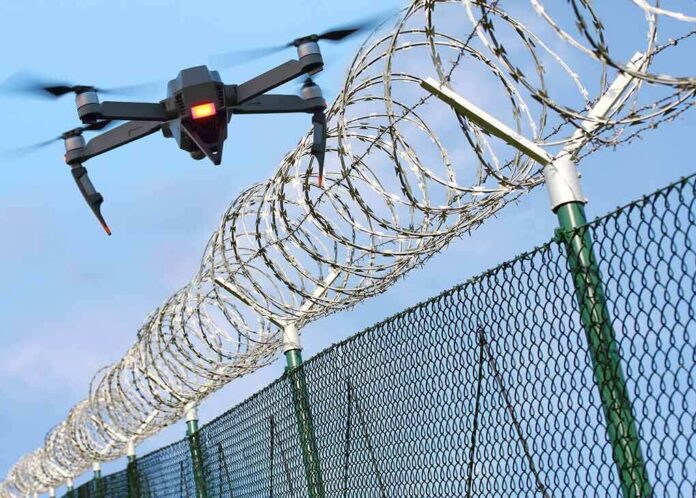 Drone flying near barbed wire security fence