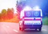Ambulance van with flashing lights on a rural road