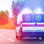 Ambulance van with flashing lights on a rural road