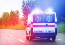 Ambulance van with flashing lights on a rural road