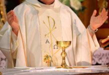 Priest celebrating Mass with chalice and open hands