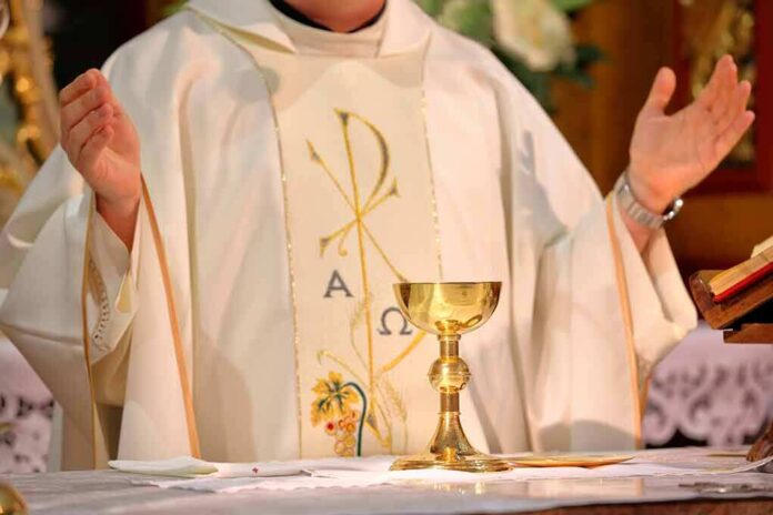 Priest celebrating Mass with chalice and open hands