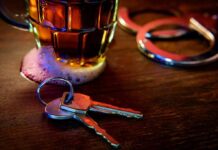 House keys on bar beside beer mug and handcuffs