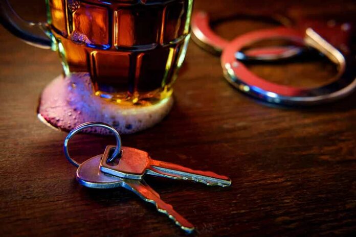 shutterstock_1064996888 House keys on bar beside beer mug and handcuffs