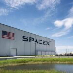 SpaceX hangar beside launch pad under blue sky