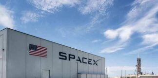 SpaceX hangar beside launch pad under blue sky