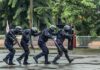 What Happened Inside Minneapolis High-Rise? Police tactical team advancing in rain