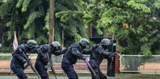 Police tactical team advancing in rain
