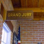 Grand jury sign in a brick-walled hallway