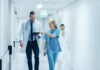 Doctor and nurse walking in a hospital corridor reviewing a tablet
