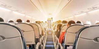 airplane cabin with passengers seated in economy class