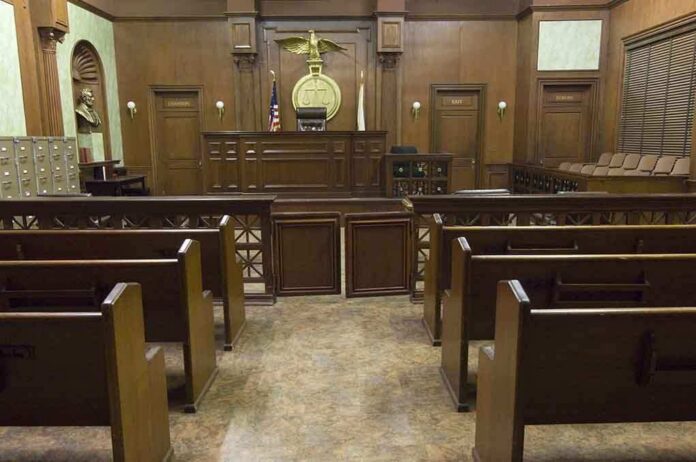 Interior view of an empty courtroom with wooden benches and a judges bench
