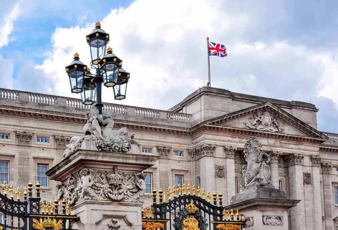 Buckingham Palace facade with Union Jack flag and ornate gate