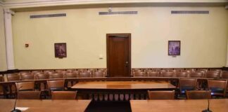 Empty courtroom with wooden tables and gallery seating